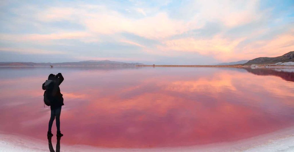 A woman taking a picture on the beach